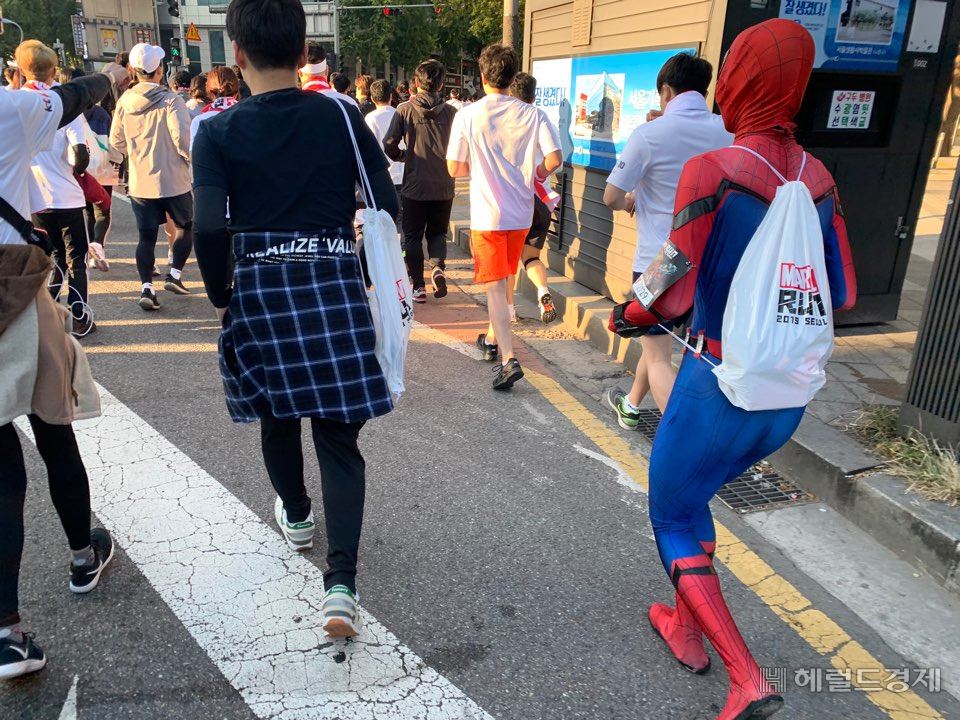 마블런 2019 서울 마라톤 10km 코스를 달리는 참가자들. 스파이더맨 코스튬을 한 참가자가 보인다. [사진=박상현 기자]