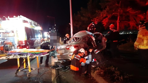 28일 새벽 울산시 북구 아산로에서 도로변으로 돌진해 멈춰선 승용차에서 소방대원들이 부상자를 구조하고 있다. [울산소방본부 제공]