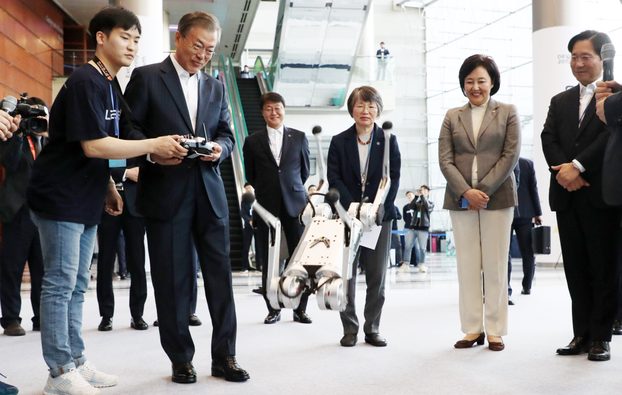 President Moon Jae-in tests a robot in Seoul on Monday. Yonhap