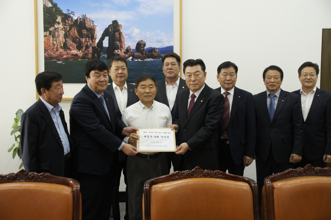 29일 농협 농정통상위원회 조합장들은 WTO 개도국 지위 포기 대책을 촉구하는 대정부•국회 건의문을 채택한 뒤 황주홍 국회 농해수위원장에게 전달하고 있다. [농협 제공]