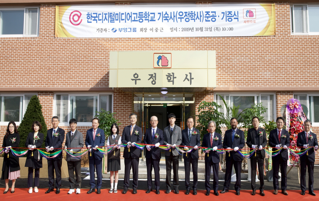지난달 31일 경기도 안산시 한국디지털미디어 고등학교 우정학사 준공식에서 관계자 및 학생 대표들이 축하 테이프를 자르고 있다. 왼쪽 일곱 번째가 김종현 이산학원 이사장, 여덟 번째가 부영그룹 신명호 회장. [부영그룹 제공]