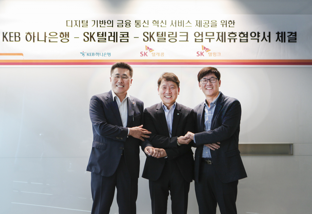 김성수 SK텔레콤 MNO사업부 영업본부장(오른쪽)이 염정호 KEB하나은행 미래금융사업본부장(가운데), 김선중 SK텔링크 대표와 ‘디지털 기반의 금융·통신 혁신 서비스 제공을 위한 양해각서(MOU)’를 체결하고 기념촬영을 하고 있다. [SK텔레콤 제공]
