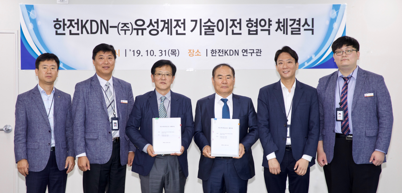정재훈(왼쪽에서 세번째) 한전KDN 전력ICT개발원장과 이진락(오른에서 세번째) 유성계전 사장이 기술이전 협약을 체결한 뒤 양측 관계자들과 기념촬영을 하고 있다. [한전KDN 제공]