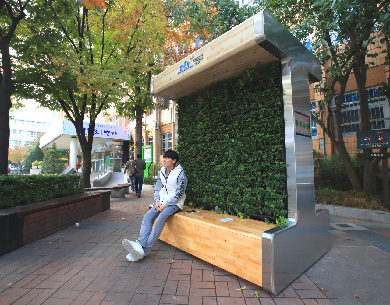 한 시민이 영등포구청 앞 뜨락에 설치된 미세먼지 저감 벤치에 앉아 휴식을 취하고 있다. [영등포구 제공]