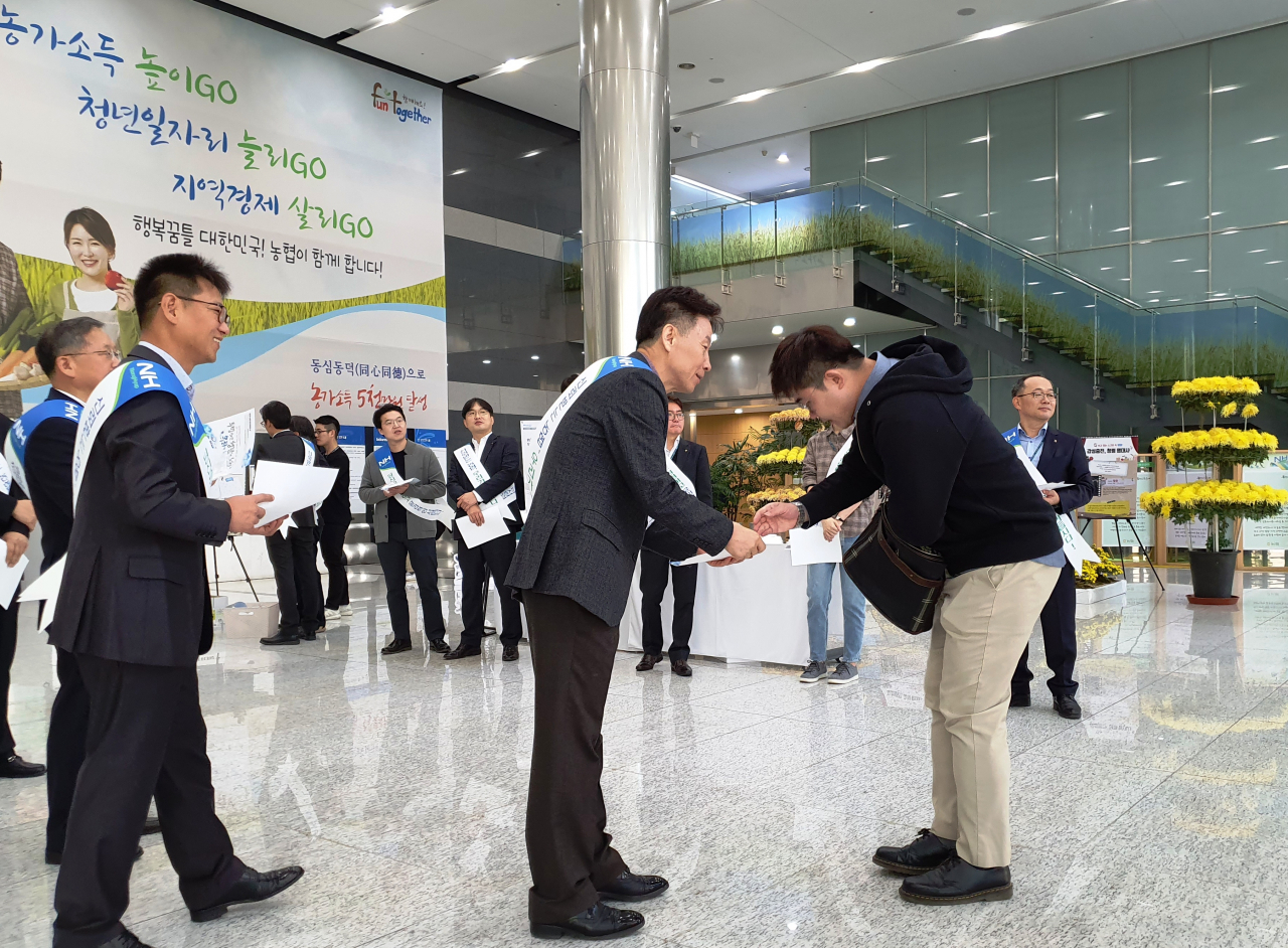 허식부 농협회장이 '제3회 윤리경영의 날' 전단지를 직원에게 나눠주고 있다. [농협 제공]