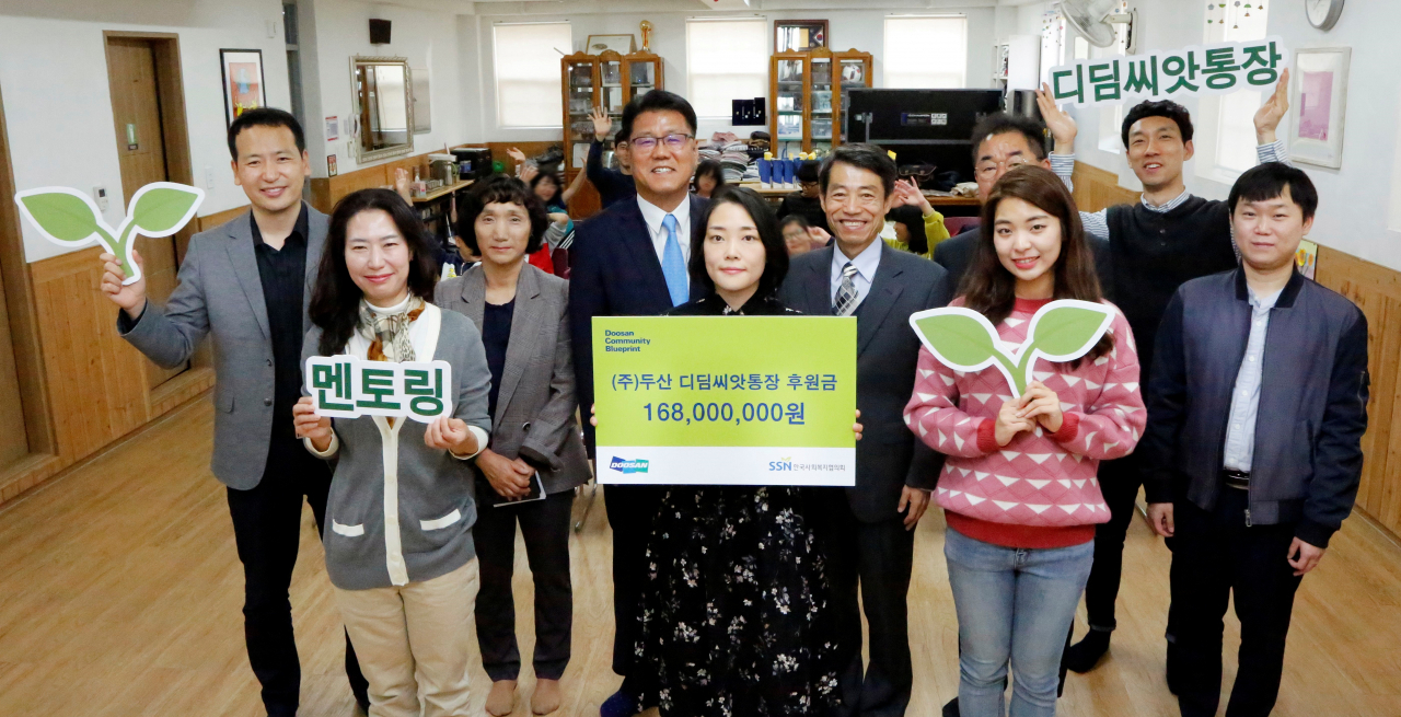 지난 2일 아동복지시설 혜심원에서 진행된 디딤씨앗통장 후원금 전달식에서 ㈜두산 임직원들과 한국사회복지협의회, 혜심원 관계자들이 기념촬영을 하고 있다.[㈜두산 제공]