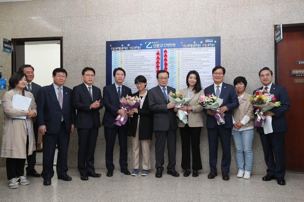 4일 오전 서울 여의도 국회 더불어민주당 당 대표 회의실 앞에서 열린 을지로위원회 상생 꽃 달기 행사에서 이해찬 대표(오른쪽 다섯번째)와 웹툰 서비스 플랫폼 케이툰(KTOON)의 불공정 관행 관련 피해 작가들이 기념촬영을 하고 있다. 연합뉴스