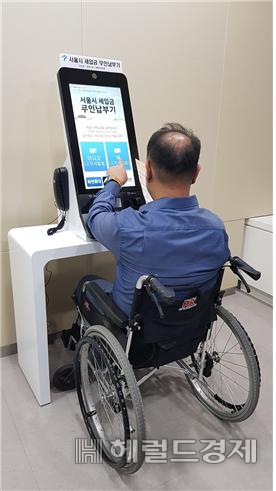 한 휠체어 이용자가 무인납부기에서 세금을 납부하고 있다. [서울시]