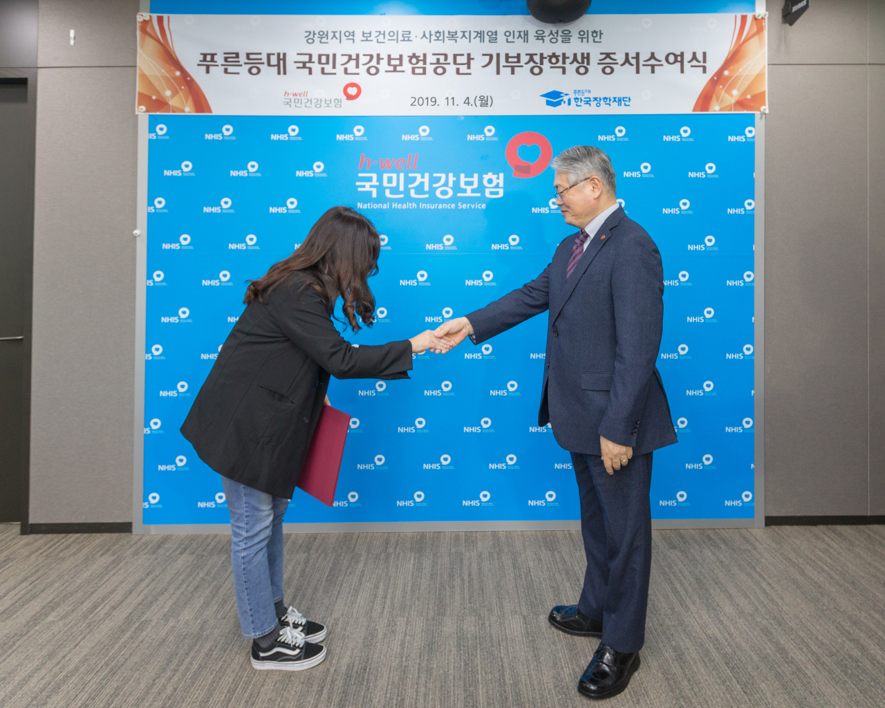 김용익 국민건강보험공단 이사장(오른쪽)이 지난 4일 강원도 원주시 공단 본부에서 강원지역 보건의료·사회복지계열 전공 대학생에게 장학금을 전달하고 있다. [건강보험공단 제공]