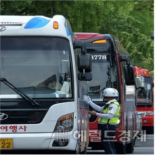 교통 경찰관이 서울 도심에서 불법 주정차 중인 관광버스를 단속하고 있다. [서울시 제공]