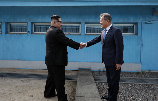 문재인 대통령과 김정은 북한 국무위원장이 지난해 4월 27일 판문점 군사분계선을 사이에 두고 악수하고 있다. [연합]