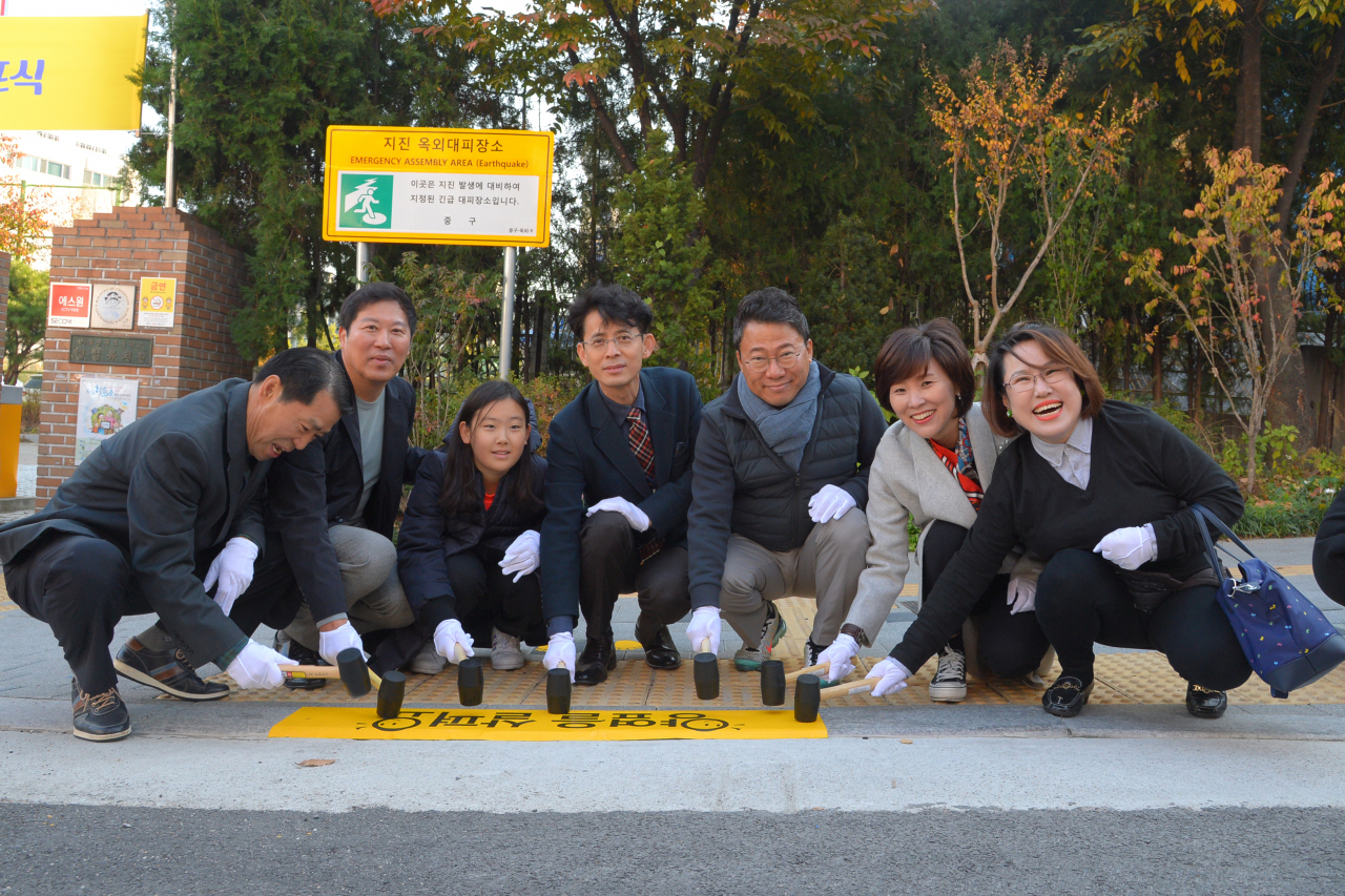 7일 충무초등학교 앞에서 열린 노란발자국 길 선포식에서 서양호(오른쪽에서 세번째) 중구청장과 참석자들이 노란색 정지선 표식을 붙이고 있다. [중구 제공]