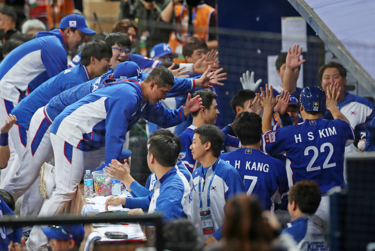 7일 오후 서울 구로구 고척스카이돔에서 열린 2019 WBSC 프리미어12 예선라운드 C조 한국과 캐나다의 경기. 9회초 2사 1,3루 한국 박민우 1타점 안타 때 홈으로 들어온 김현수가 동료들의 축하를 받고 있다. [연합]