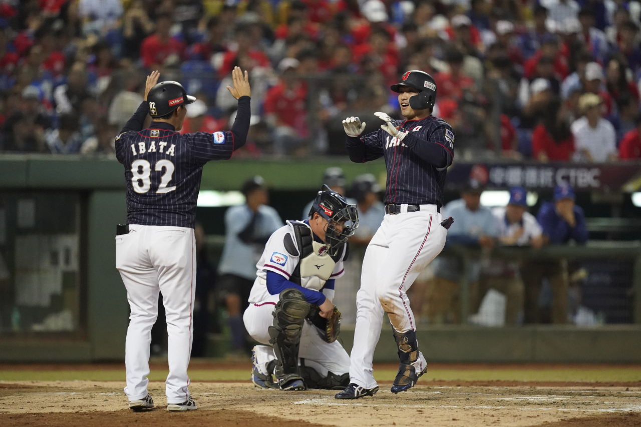 지난 7일 대만 타이중 인터콘티넨털구장에서 열린 2019 세계야구소프트볼연맹(WBSC) 프리미어12 B조 조별 리그 3차전 대만-일본전. 3회초 일본의 스즈키 세이야(오른쪽)가 2점 홈런을 치고 홈으로 들어오며 앞선 주자의 환영을 받고 있다. 일본 선수들 사이로 고개를 떨군 대만 포수 린훙유(가운데)의 모습이 눈에 띈다. [EPA]