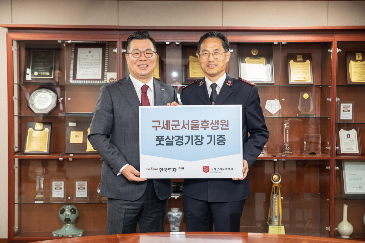 11일 서울 여의도 한국투자증권 본사에서 정일문 한국투자증권 사장(왼쪽)과 김호규 구세군서울후생원 원장(오른쪽)이 풋살경기장 기증식을 갖고 기념촬영을 하고 있다. [한국투자증권]
