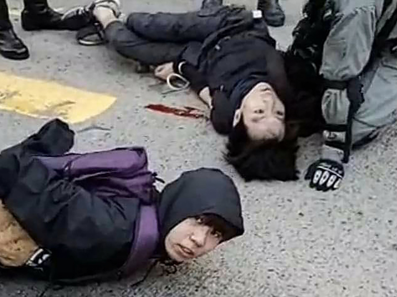 11일(현지시간) 홍콩 사이완호에서 시위 중 한 참가자(위)가 경찰이 쏜 실탄에 가슴 부분을 맞아 피를 흘리며 쓰러져 있다. 경찰과 가면 쓴 시위대의 대치 현장이 페이스북에 생중계된 가운데 최소 한 명이 경찰이 쏜 총에 다쳤으며 출퇴근 시간 시위로 혼란이 빚어졌다. [연합]
