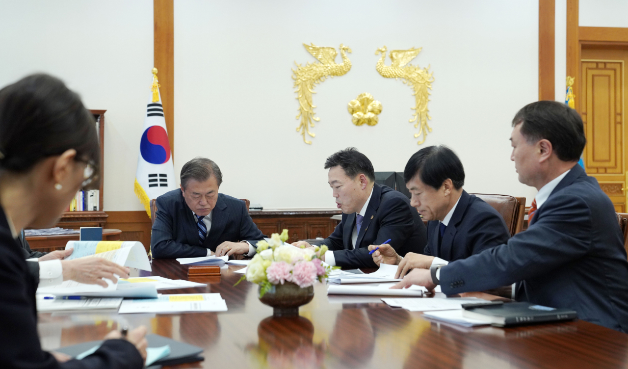 President Moon Jae-in recieves a briefing from Vice Minister of Justice Kim O-su on Friday. Yonhap