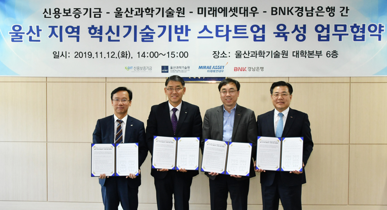 12일 울산 스타트업 육성 업무 협약식에서 협약 기관 대표 참석자들이 협약서를 들어보이고 있다. [BNK경남은행 제공]