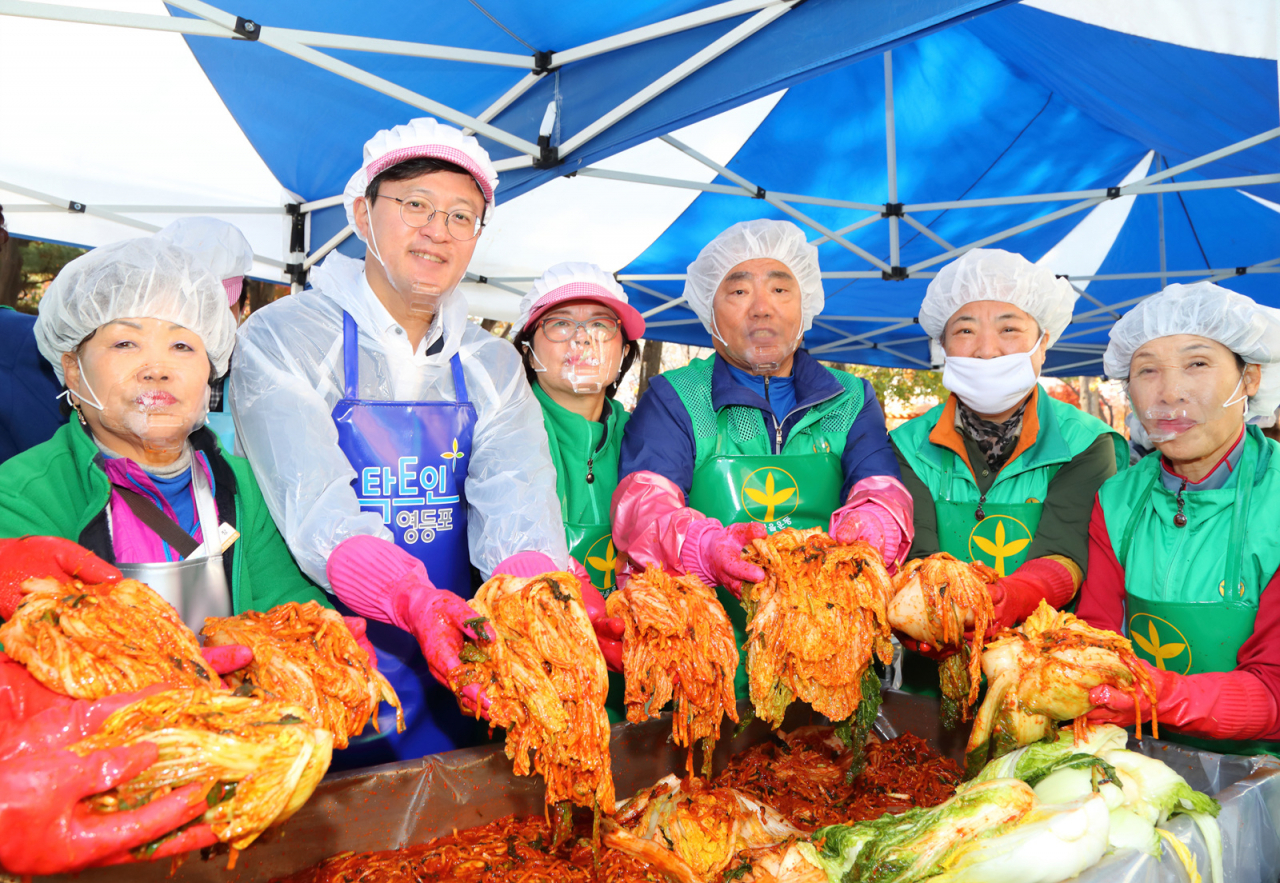 지난해 11월 구청 광장 및 당산공원에서 개최된 제7회 사랑의 김장나누기 한마당에서 채현일구청장과 봉사자들이 김장을 담그고 있는 모습. [영등포구 제공]
