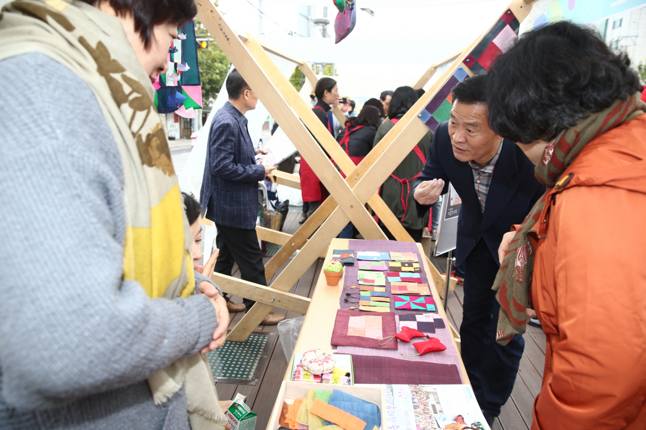 지난 10일 성북구청 앞 바람마당에서 열린 ‘성북 50플러스센터와 함께하는 이토록 멋진 마을’ 행사에서 이승로 성북구청장이 참여 부스 주민들과 인사를 나누고 있다. [성북구 제공]