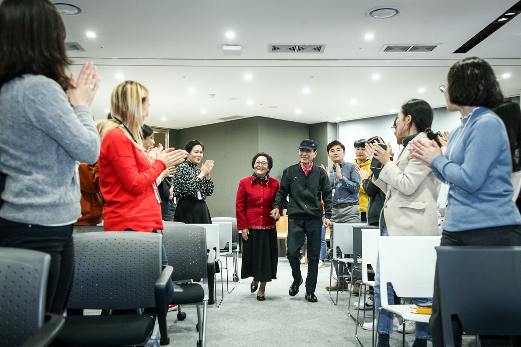 은퇴식에 참석한 맥도날드 최고령 시니어 크루 임갑지님(오른쪽)과 아내 최정례 여사(왼쪽)가 맥도날드 임직원의 환호를 받으며 입장하고 있는 모습. [한국맥도날드 제공]