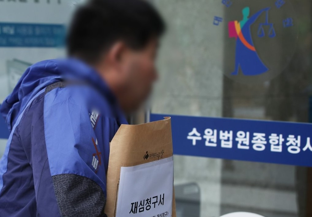 화성8차사건 윤모씨가 재심청구서를 들고 13일 오전 경기도 수원시 영통구 수원지방법원으로 들어가고 있다. [연합]