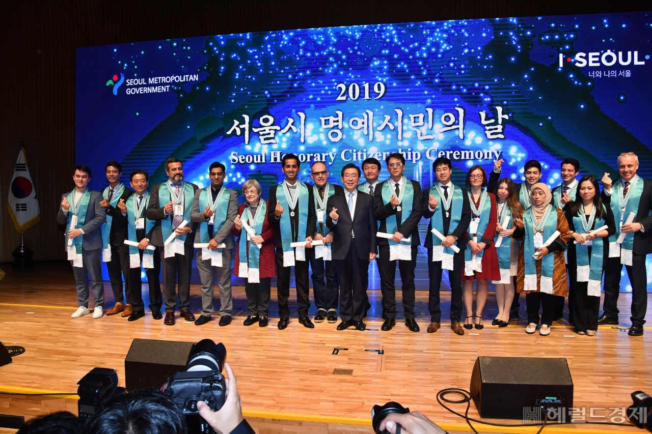 지난 13일 오후 서울 태평로 시청 다목적홀에서 열린 2019 서울시 외국인 명예시민의 날 행사에서 박원순 서울시장(가운데)이 이날 서울시 명예시민증을 받은 외국인 참석자들과 손가락으로 하트를 만들며 기념촬영을 하고 있다. 서울시는 올해 14개국 18명의 외국인을 '2019년 서울시 명예시민'으로 선정하고 박원순 서울시장이 명예시민증을 수여했다. 외국인 명예시민은 서울 시정 발전에 기여한 외국인들과 서울을 방문하는 외국원수 등 지금까지 총 98개국 853명이 선정됐다. [서울시]
