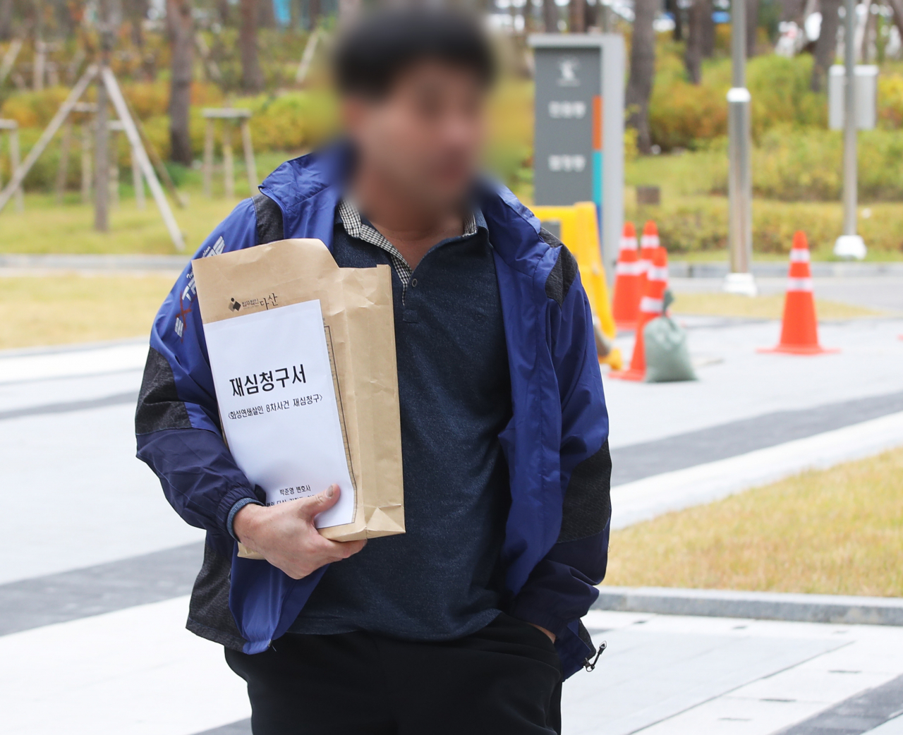 화성연쇄살인 8차 사건의 범인으로 검거돼 20년간 '억울한 옥살이'를 했다고 주장해 온 윤모(52) 씨가 재심청구서를 들고 13일 오전 경기도 수원시 영통구 수원지방법원으로 들어가고 있다. [연합]