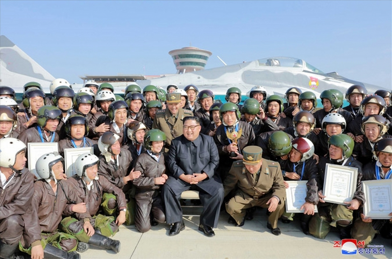 김정은 북한 국무위원장이 원산갈마비행장에서 열린 전투비행술경기대회를 참관했다고 조선중앙통신이 16일 보도했다. 중앙통신 홈페이지에 공개한 사진에서 김 위원장이 경기대회에 참가한 조종사 등과 기념사진을 찍고 있다. [연합]