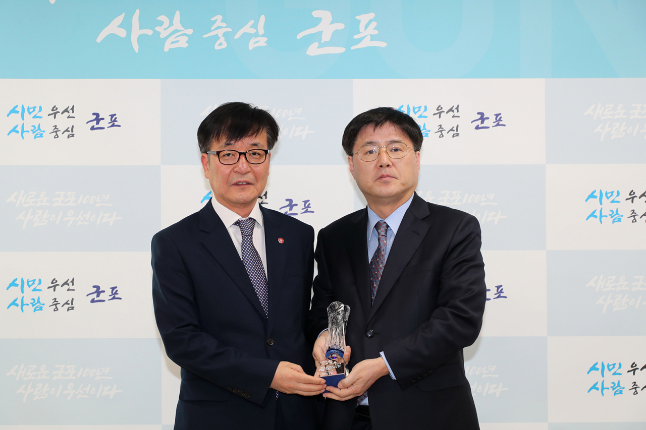 한대희 군포시장(사진 우측)이 이명한 국민건강보험공단 군포지사장으로부터 감사패를 받고 있다. [군포시 제공]
