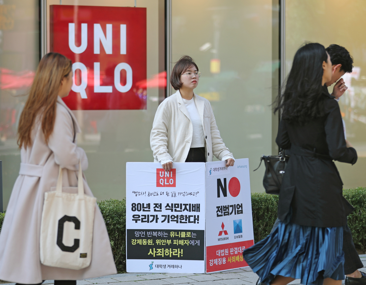 지난달 24일 서울 종로구 유니클로 광화문 디타워점 앞에서 대학생겨레하나 회원 이진희 씨가 유니클로를 비롯한 일제 강제징용 기업을 규탄하는 1인 시위를 하고 있는 모습. [연합]