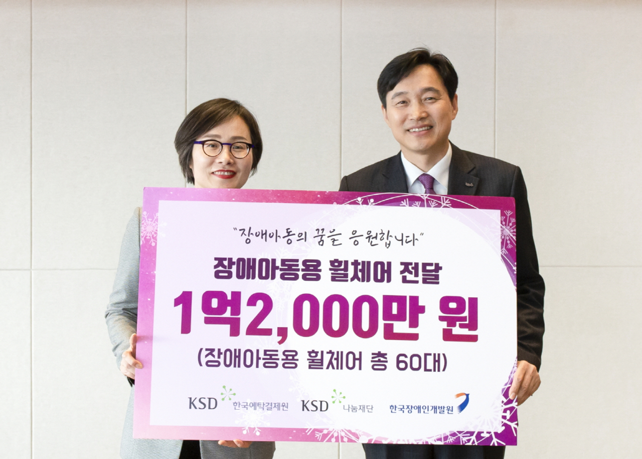 이병래 한국예탁결제원 KSD나눔재단 이사장(오른쪽)과 최경숙 한국장애인개발원장이 18일 롯데월드타워 컨벤션홀에서 열린 장애아동 유모차형 휠체어 지원식에서 기념촬영을 하고 있다. [한국예탁결제원 제공]