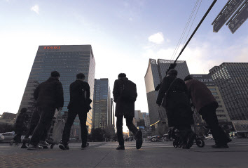 18일 정부가 내년부터 시행키로 한 50~299인 규모의 기업에 대한 주 52시간 근로제 적용을 한시적으로 유예키로 했다. 이날 오후 직장인으로 보이는 시민들이 해질녘 광화문네거리를 지나고 있다. [연합]