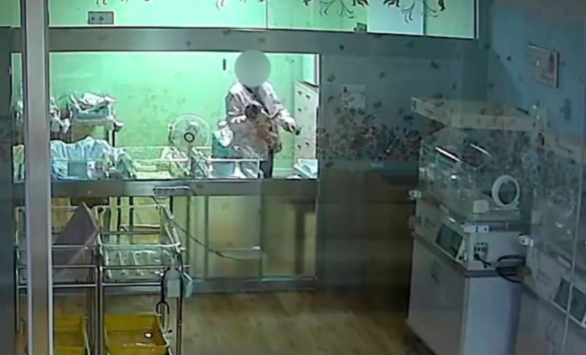 A screen grab from the CCTV footage showing the nurse holding the newborn by the neck with one hand on Oct. 20. (Yonhap)