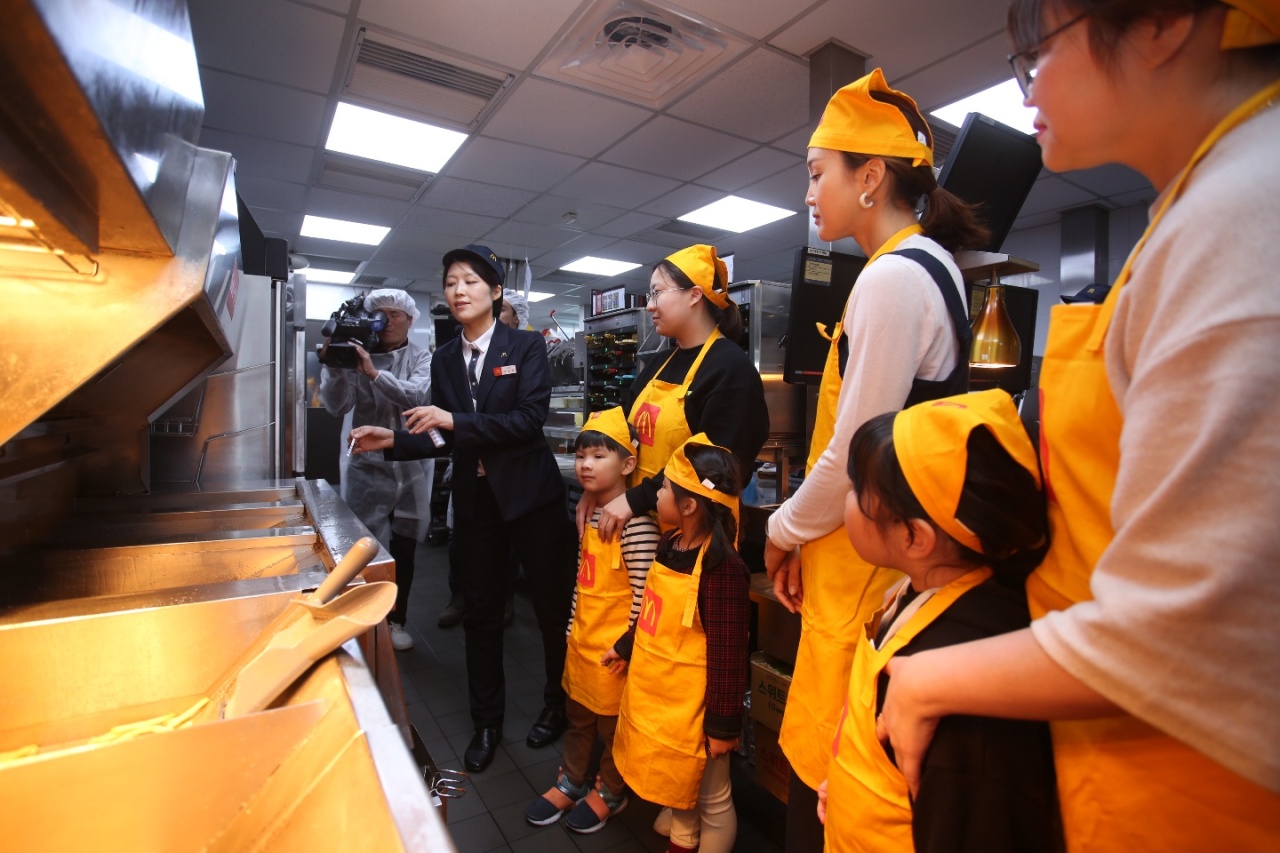 A McDonald's employee explains its cooking oil replacement system to its customers. (McDonald's)