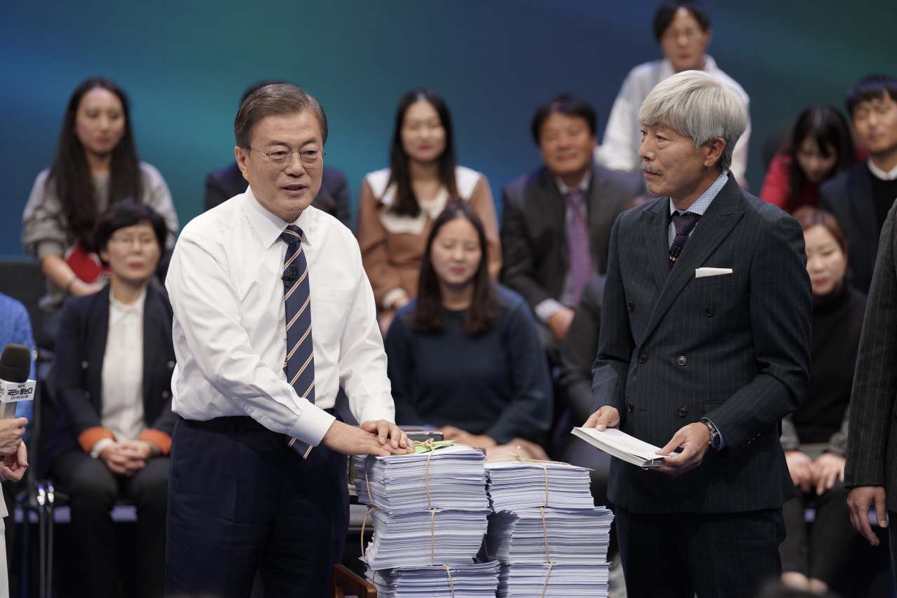 문재인 대통령이 19일 오후 서울 상암동 MBC에서 '국민이 묻는다, 2019 국민과의 대화' 종료 후 시간 관계상 받지 못한 질문지를 전달받고 있다. [연합]