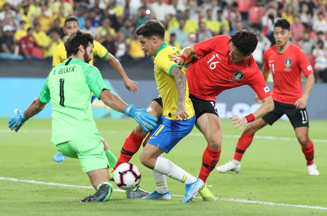 19일(현지시간) 아랍에미리트(UAE) 아부다비 모하메드 빈 자예드 스타디움에서 열린 한국과 브라질 축구 대표팀 평가전에서 한국 황의조가 브라질 쿠티뉴와 골키퍼 알리송을 피해 슈팅을 시도하고 있다. [연합]