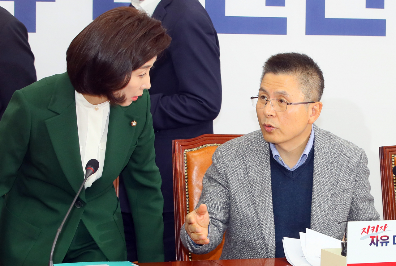 황교안 자유한국당 대표(오른쪽)와 나경원 원내대표가 18일 국회에서 열린 최고위원회의에서 논의하며 자리에 앉고 있다. [연합]