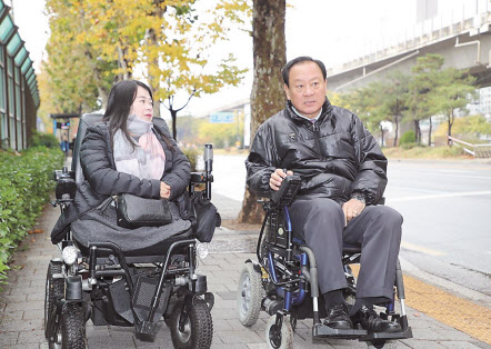 지난 15일 마포구청에서부터 마포중앙도서관까지 유동균 마포구청장(오른쪽)이 휠체어를 타고 이동하고 있다. [마포구 제공]
