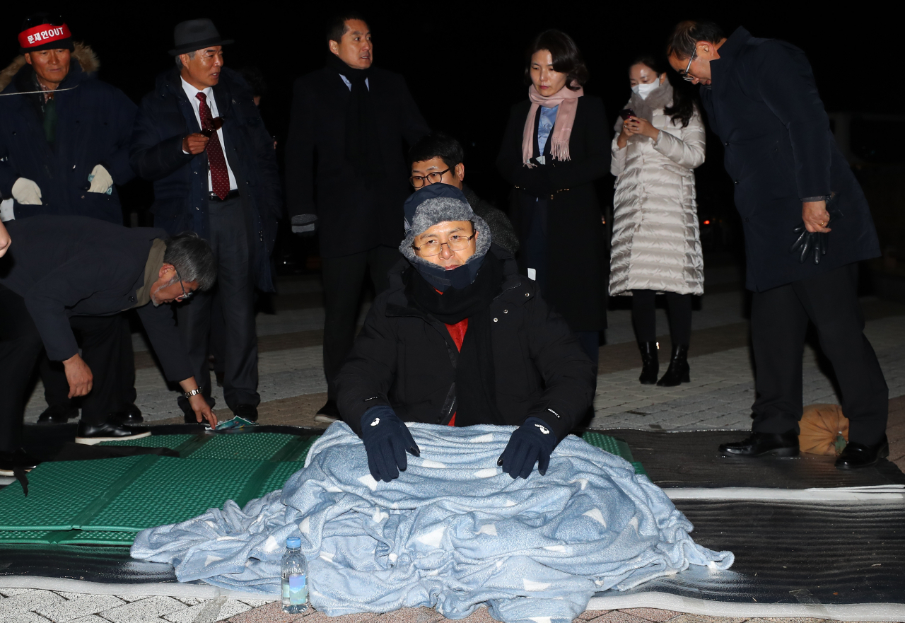 국정 대전환을 촉구하는 단식투쟁을 시작한 황교안 자유한국당 대표가 20일 오후 청와대 앞에서 담요를 덮고 자리를 지키고 있다. [연합]