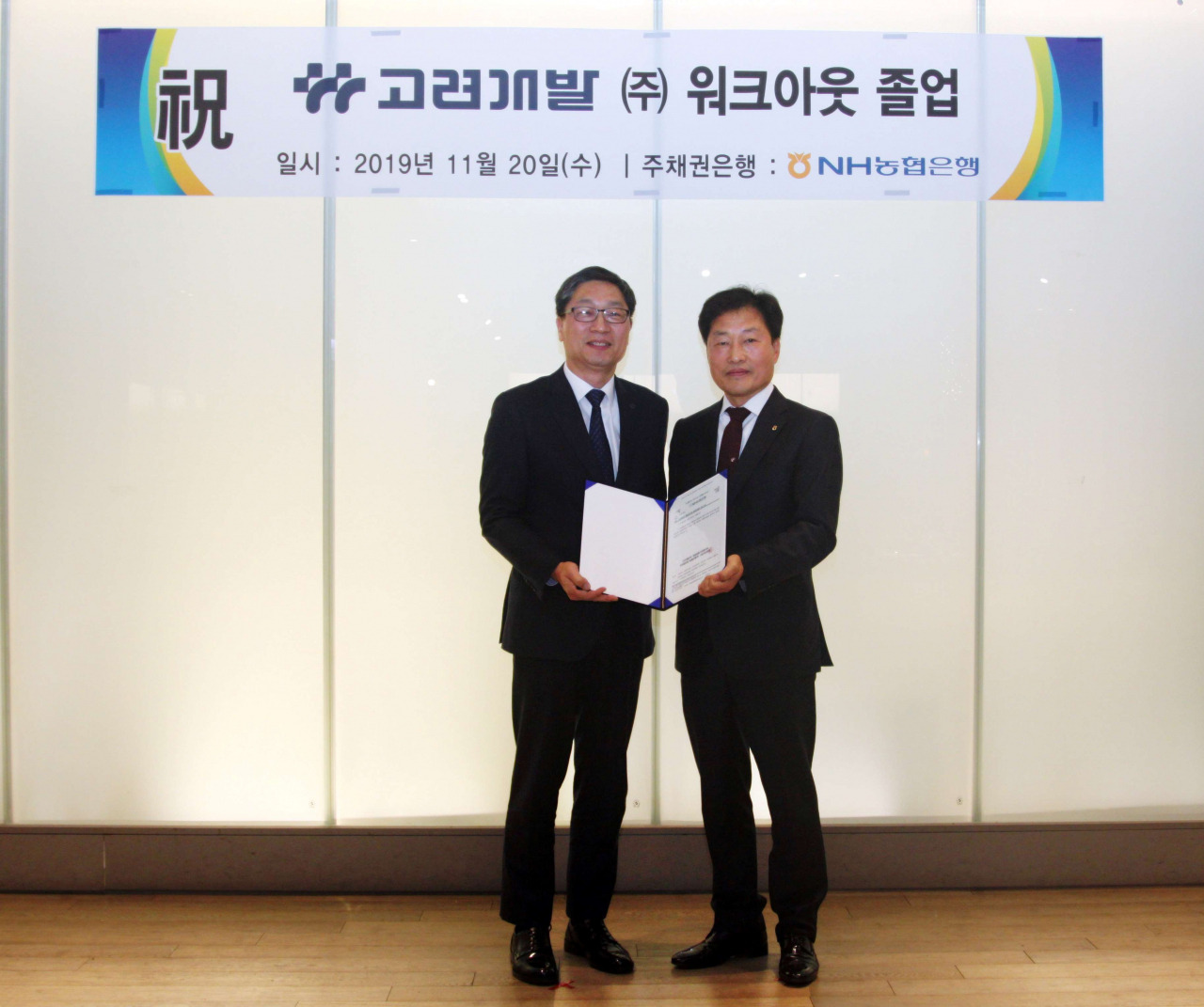 20일 신라스테이 서대문점에서 열린 워크아웃 졸업 기념 행사에 참석한 곽수윤 고려개발 대표(왼쪽)와 박성일 NH농협은행 부장이 채권금융기관 공동관리절차 종결 통지문을 교환하며 기념사진을 촬영하고 있다.