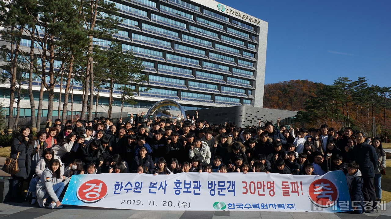 한수원이 20일 본사 홍보관 30만번째 방문객인 경주 화랑중학교 1학년 학생들과 단체기념 사진을 찍고 있다.[한국수력원자력 제공]