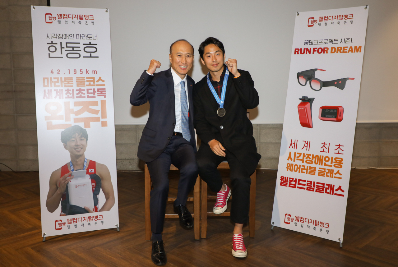 김대웅 웰컴저축은행 대표(왼쪽)와 시각장애인 마라토너 한동호 선수가 21일 서울 합정동에서 진행된 기자간담회에서 포즈를 취했다.