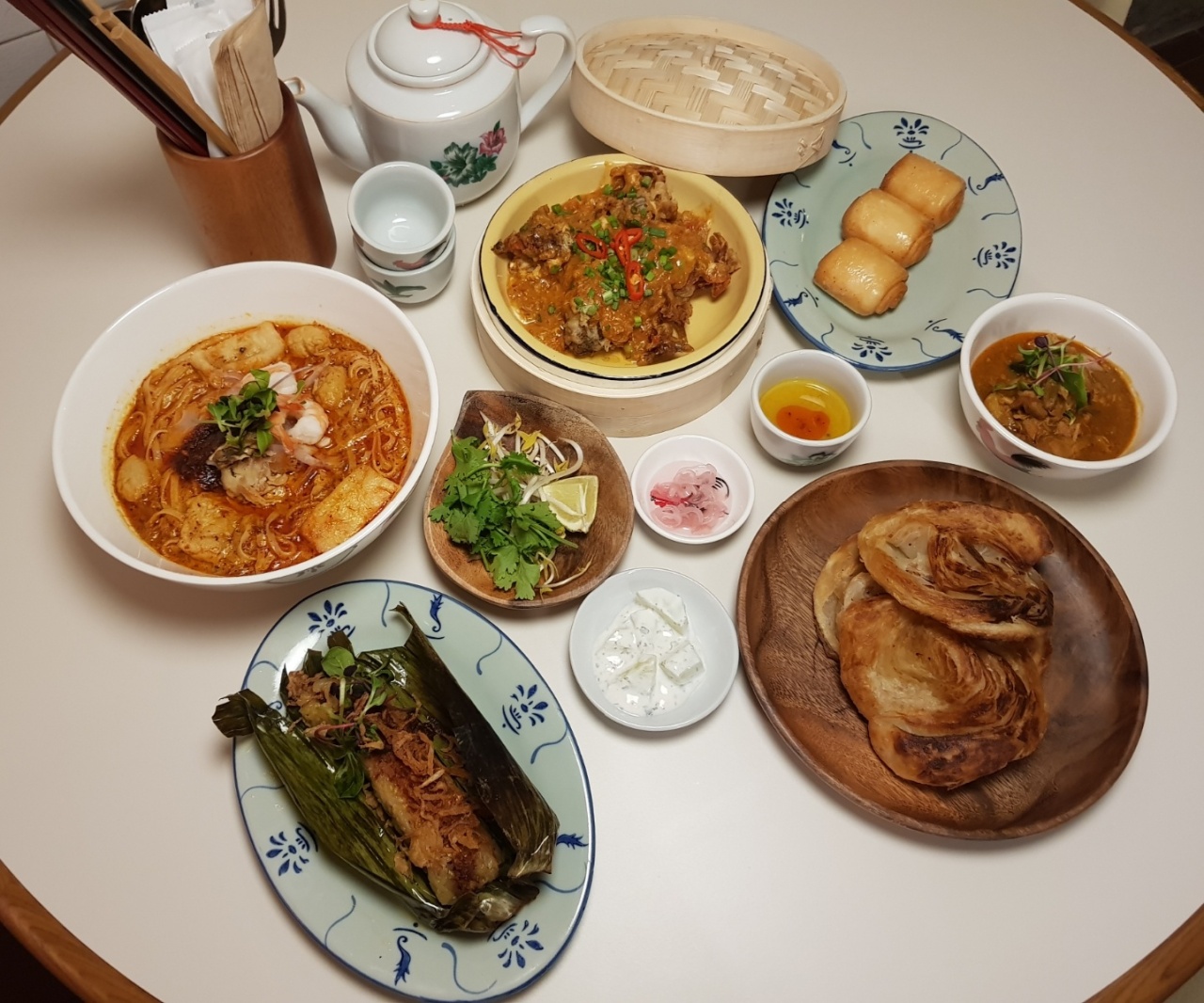 Clockwise from top left: Nyonya laksa, chili crab with fried mantou buns, chicken curry and roti canai and pulut panggang (Choi Ji-won/The Korea Herald)