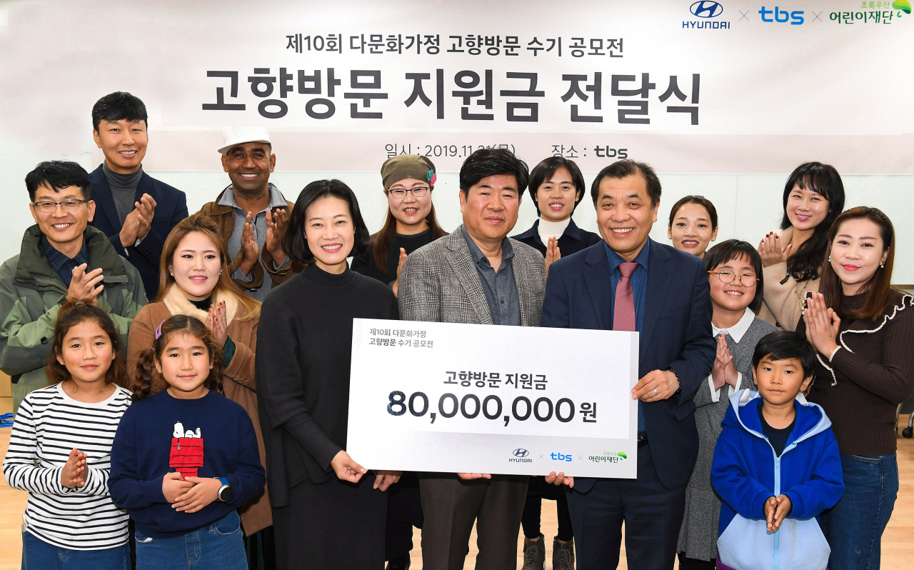 초록우산 어린이재단 여인미 서울지역본부장(가운데 왼쪽부터), 현대차 국내판촉실 송성호 상무, tbs교통방송 이강택 대표 등 관계자와 우수작으로 선정된 20명 가족들이 전달식에서 기념 촬영을 하고 있다. [현대차 제공]