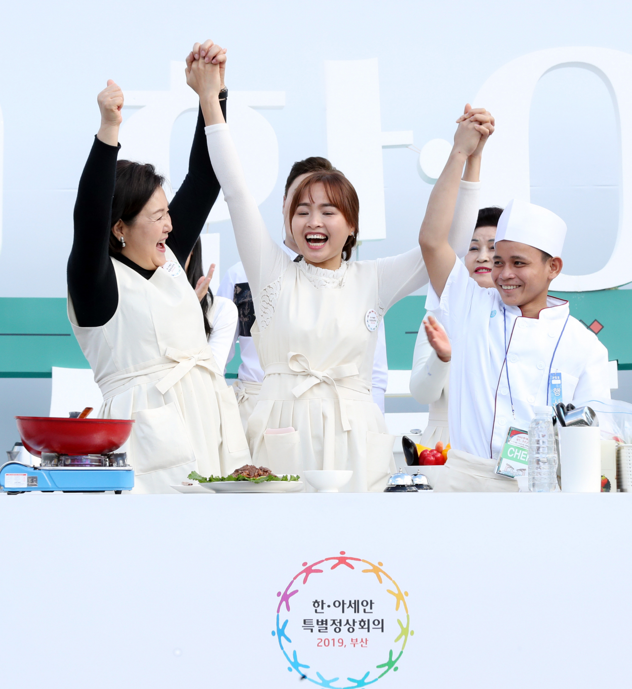 문재인 대통령의 부인 김정숙 여사가 22일 부산 전포동 놀이마루에서 열린 한-아세안 정상회의 D-3일 기념 음식 경연대회에서 캄보디아 팀으로 화합상을 받은 후 환호하고 있다. [연합]