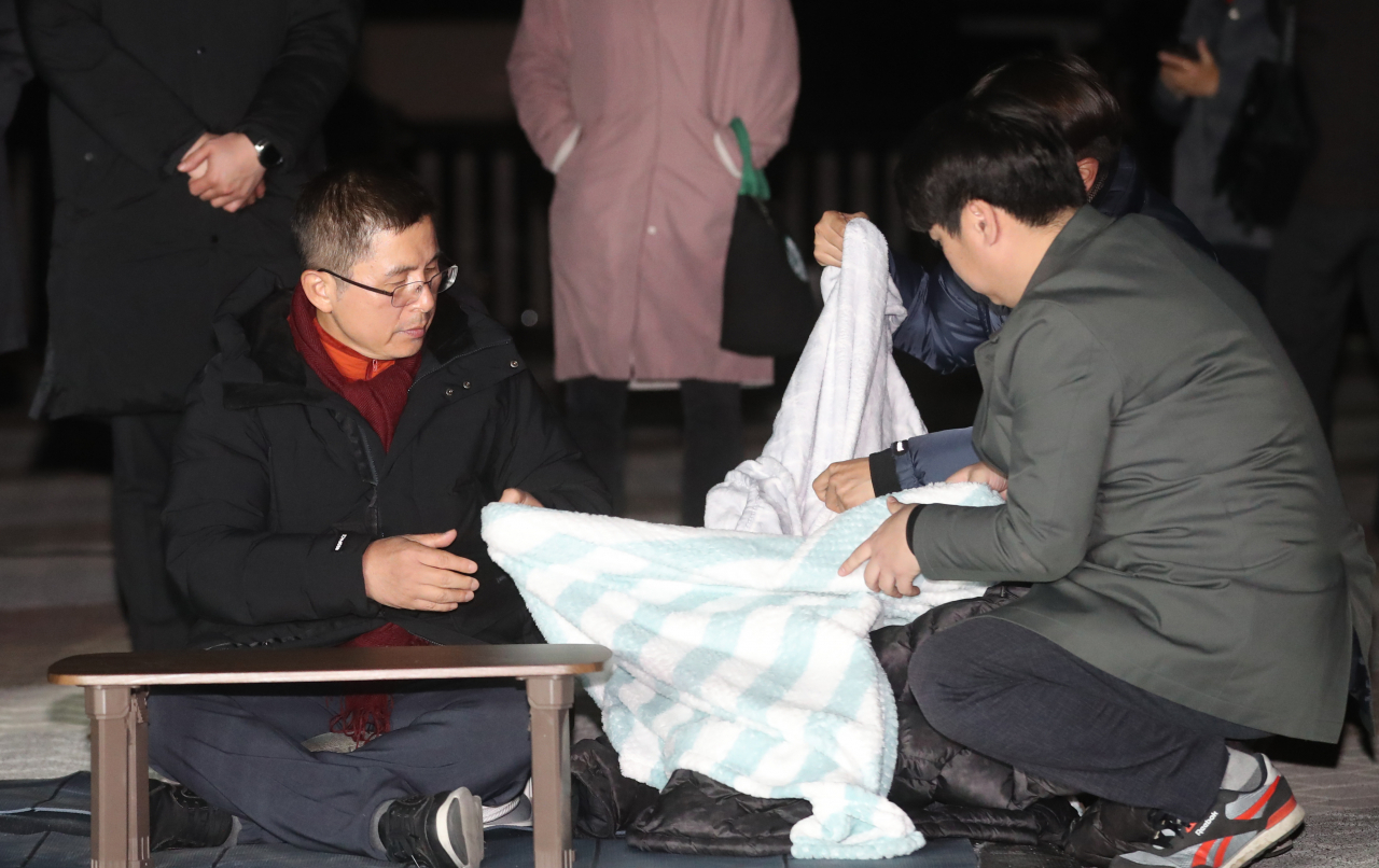 3일째 단식 중인 자유한국당 황교안 대표가 22일 오후 청와대 앞 분수대 광장에서 강기정 청와대 정무수석에게 지소미아 효력정지 연기 관련 설명을 들은 후 담요를 덮고 있다. [연합]