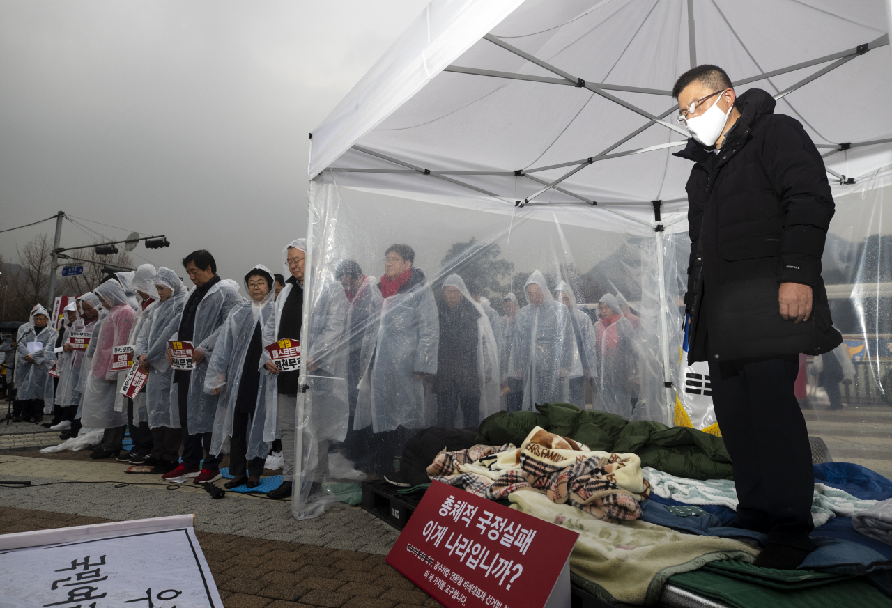 24일 오후 황교안 자유한국당 대표가 단식 중인 청와대 앞 분수대 광장에서 열린 한국당 비상 의원총회에서 묵념을 하고 있다. [연합]