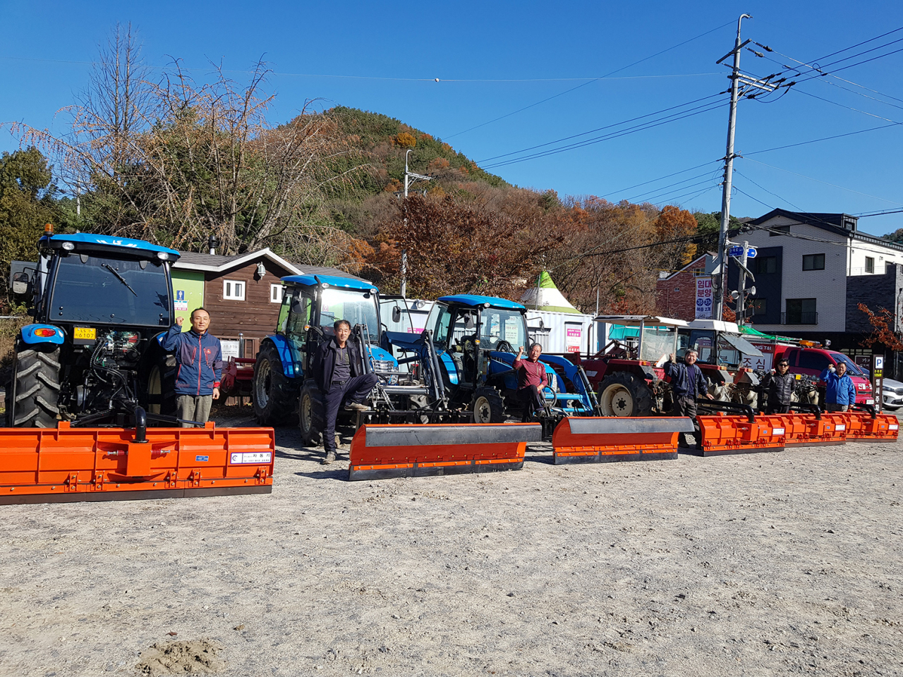 제설 삽날을 장착한 트렉터 앞에서 겨울철 활약을 다짐하는 군포시 자율방재단 단원들 [군포시 제공]