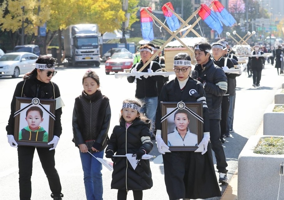 North Korean defectors march in a protest in the Gwanghwamun area in downtown Seoul on Nov. 8, 2019, calling for a probe into the cause of the death of a 42-year-old female North Korean defector and her six-year-old son who were found dead in July apparently due to extreme poverty. (Yonhap)